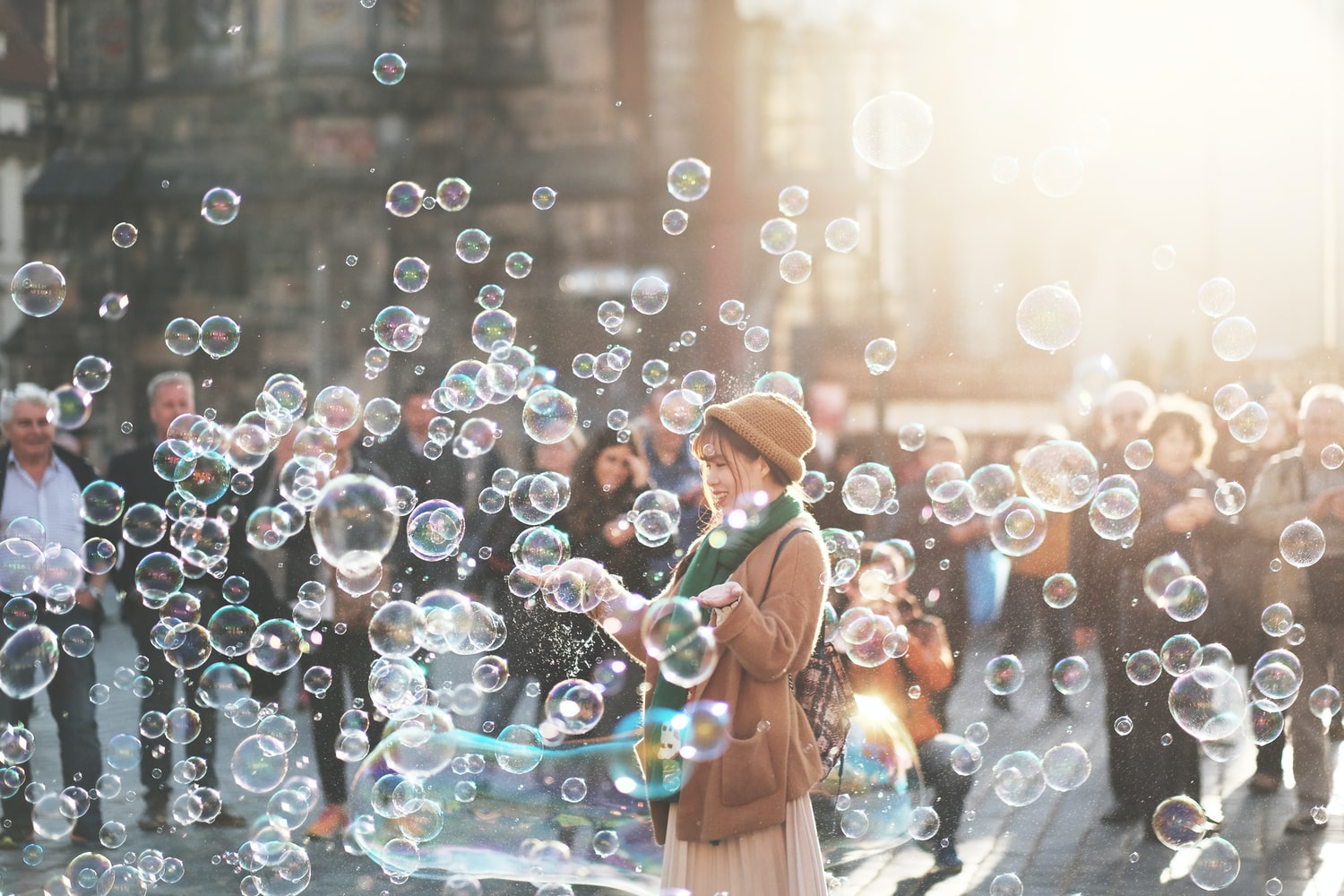 Woman blowing soap bubbles on a busy street